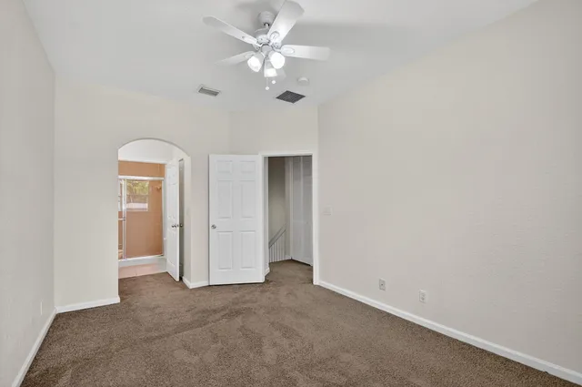a view of a room with a ceiling fan and closet