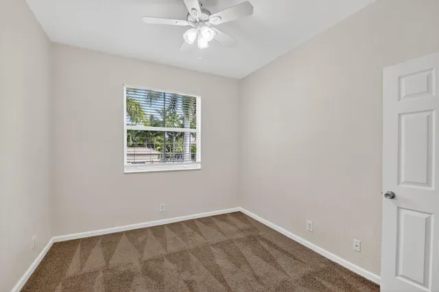 an empty room with a window and a fan
