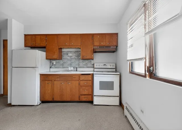 a kitchen with stainless steel appliances granite countertop a refrigerator a stove and a sink