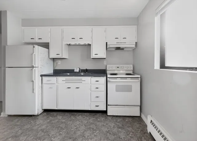 a white kitchen with cabinets and white appliances