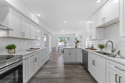 a kitchen with white cabinets stove and sink