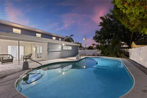 an aerial view of a house with swimming pool outdoor seating and yard