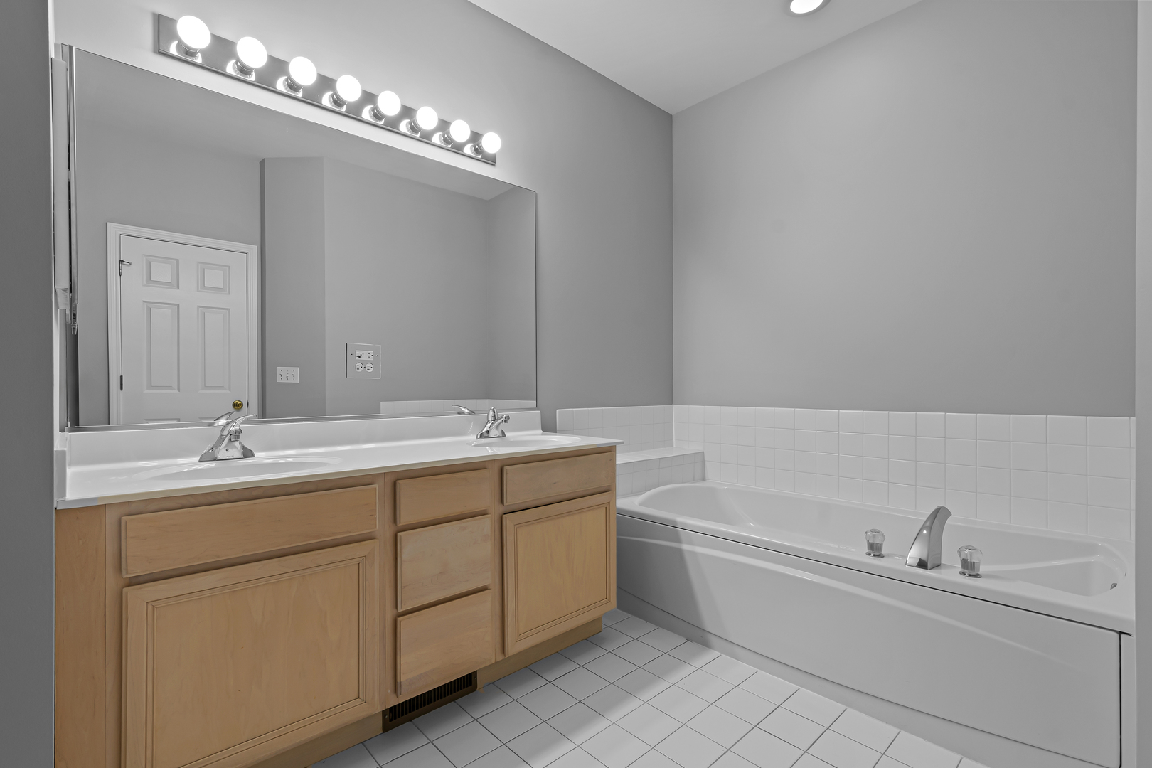 4319 Exeter Lane Northbrook, IL 60062 - Photo 11 of 24 a bathroom with a double vanity sink a large mirror and a bathtub