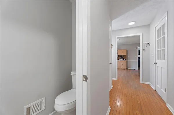 a view of a hallway with wooden floor and stairs