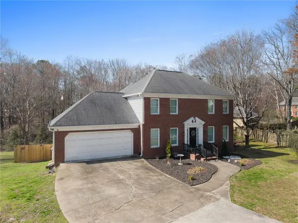 a front view of a house with yard porch and tree