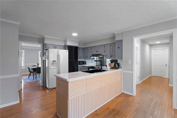 a kitchen with stainless steel appliances granite countertop a sink stove and wooden floor
