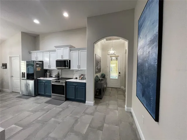 a large kitchen with a large counter top stainless steel appliances and cabinets