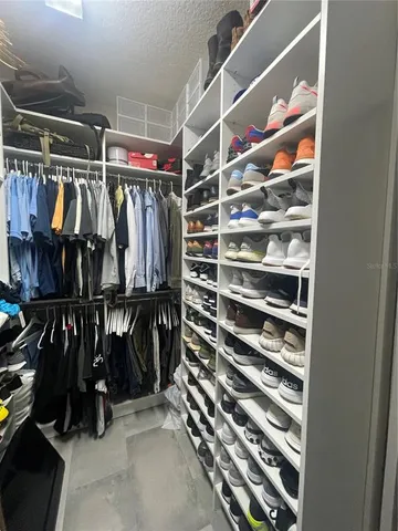 a view of walk in closet with clothes and shoes