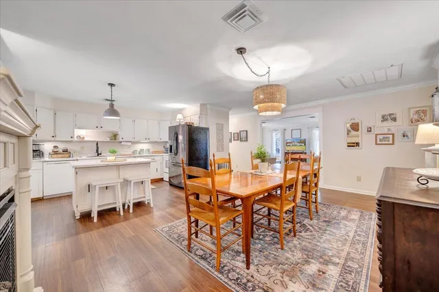 a bedroom with a bed chandelier dresser and a window