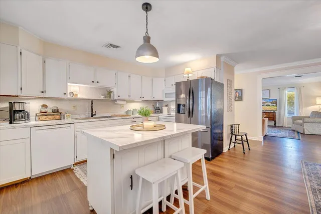 a living room with patio furniture and a floor to ceiling window