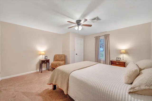 a view of a house with a big yard and large trees