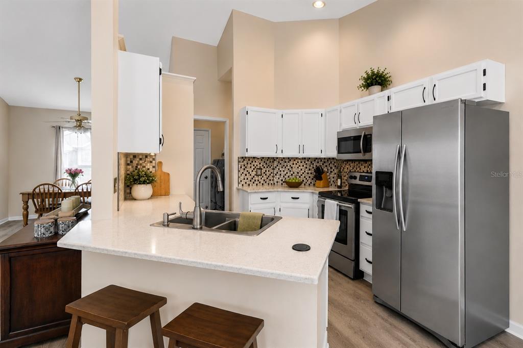12232 Bronson Way Orlando, FL 32824 - Photo 10 of 32 a kitchen with refrigerator and chairs