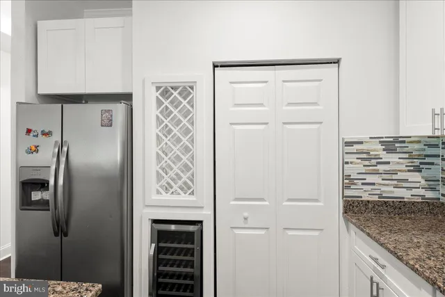 a view of a refrigerator in kitchen and cabinets