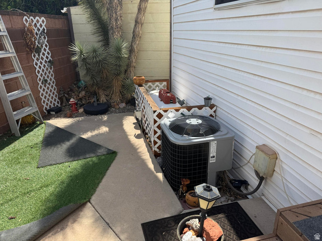1225 North Dixie Downs Road, Unit 100 St. George, UT 84770 - Photo 16 of 22 Concrete patio area with a white lattice fence, leading to a section of artificial turf