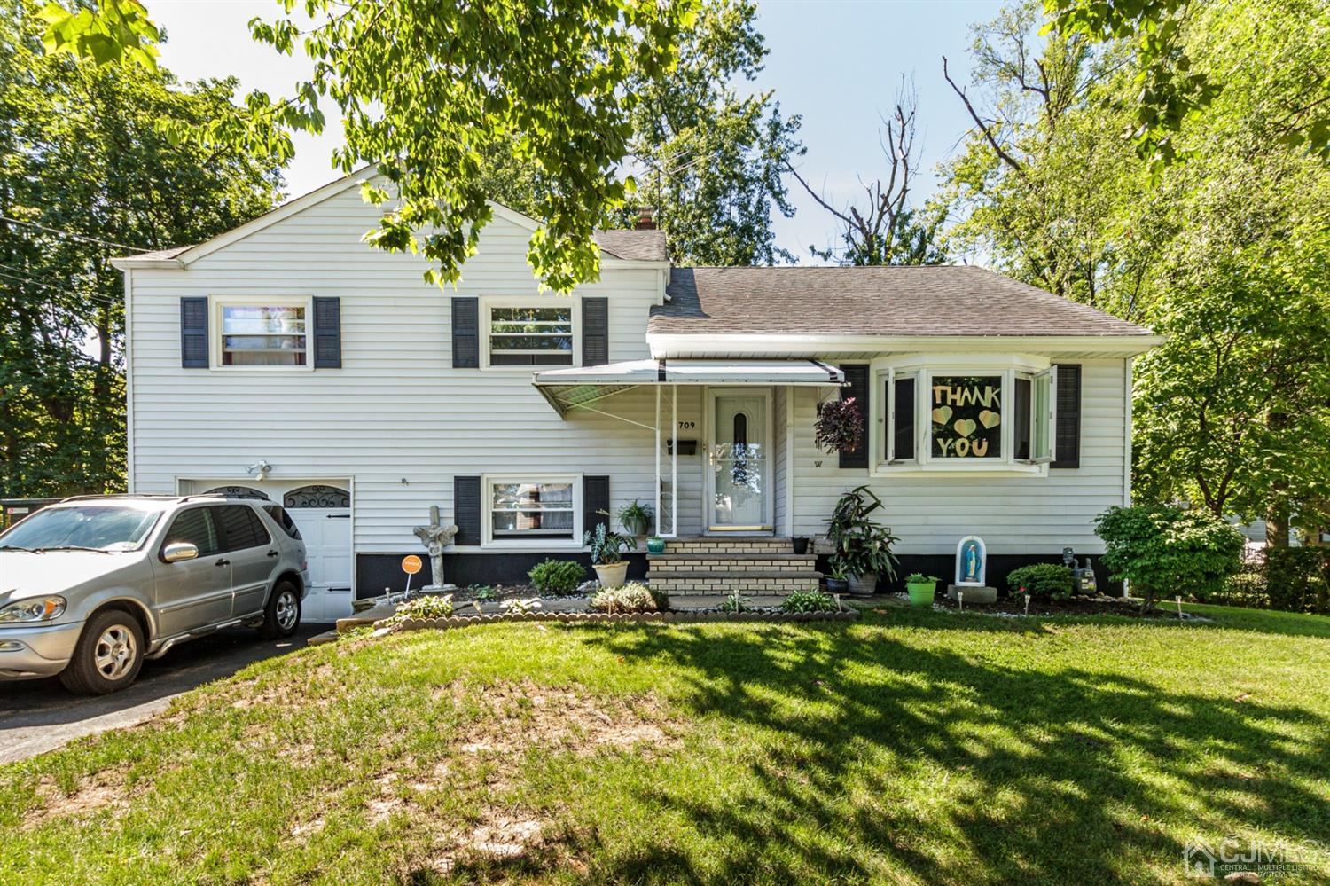 709 Exeter Road Linden, NJ 07036 - Photo 1 of 28 a view of a white house with a large pool lawn chairs and a yard