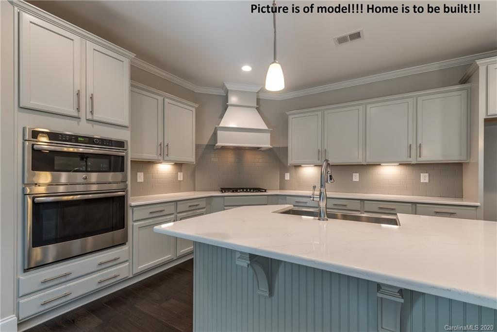 2061 New Style Way, Unit 30 Tega Cay, SC 29708 - Photo 25 of 40 a kitchen with kitchen island a sink stainless steel appliances and cabinets