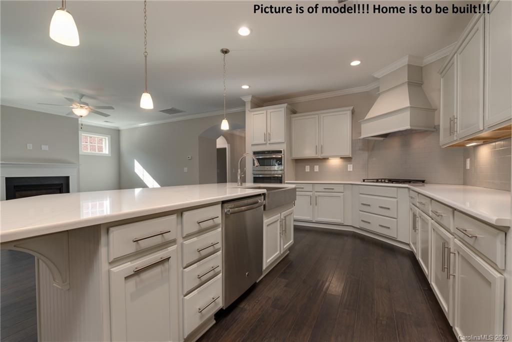 2061 New Style Way, Unit 30 Tega Cay, SC 29708 - Photo 28 of 40 a kitchen with white cabinets appliances and a chandelier