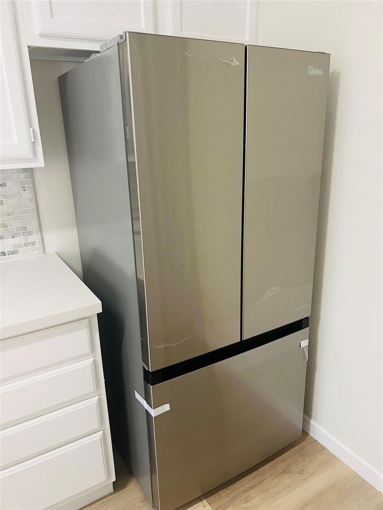 2668 Bering Drive, Unit 2668 Houston, TX 77057 - Photo 6 of 47 a view of a refrigerator in kitchen and an empty room