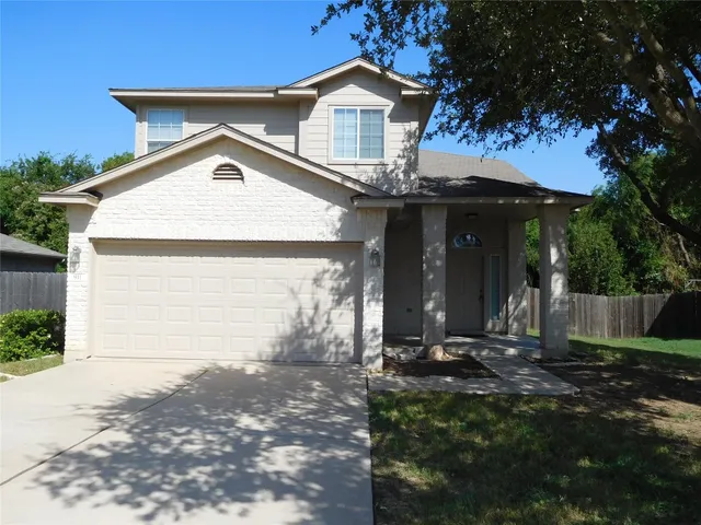 a view of a house with a yard and large tree