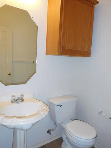 a bathroom with a sink a toilet and mirror