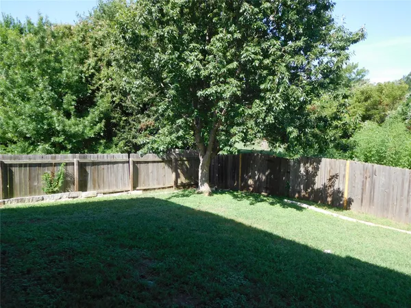 a yard with trees in the background