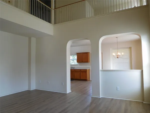 a view of a hallway with wooden floor and a cabinet