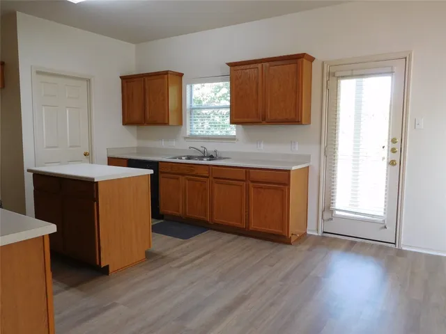 a kitchen with a sink cabinets and wooden floor