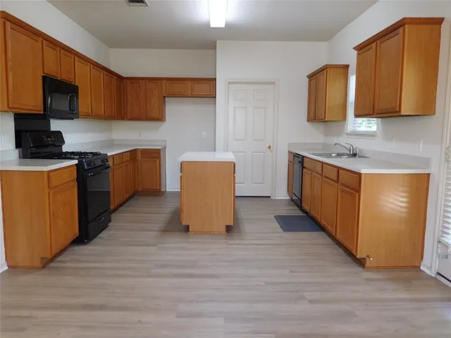 a kitchen with stainless steel appliances granite countertop a stove a sink and a microwave