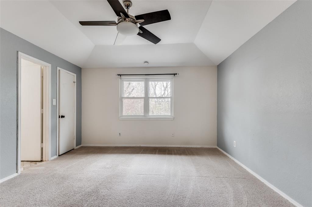 2749 Buna Drive Dallas, TX 75211 - Photo 8 of 12 Primary bedroom with light colored carpet, ceiling fan, and lofted ceiling