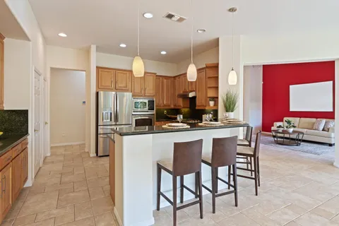 a kitchen with stainless steel appliances kitchen island granite countertop a refrigerator and a stove top oven