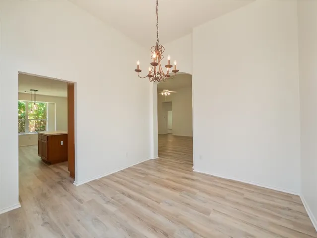 a large kitchen with stainless steel appliances kitchen island granite countertop a stove a sink a refrigerator and a granite countertops with wooden floor