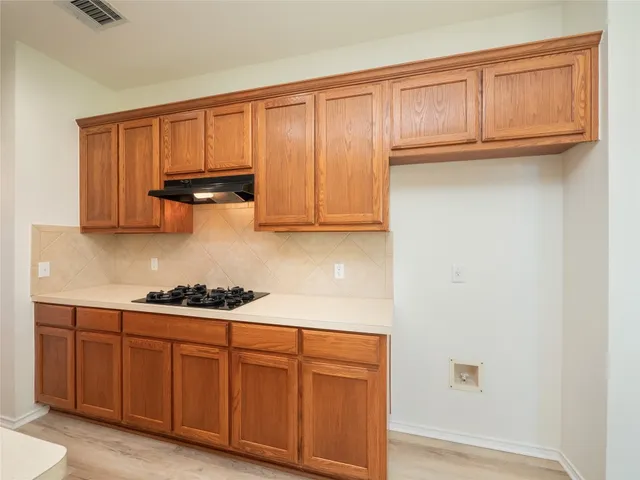 a kitchen with a sink stove and wooden cabinets