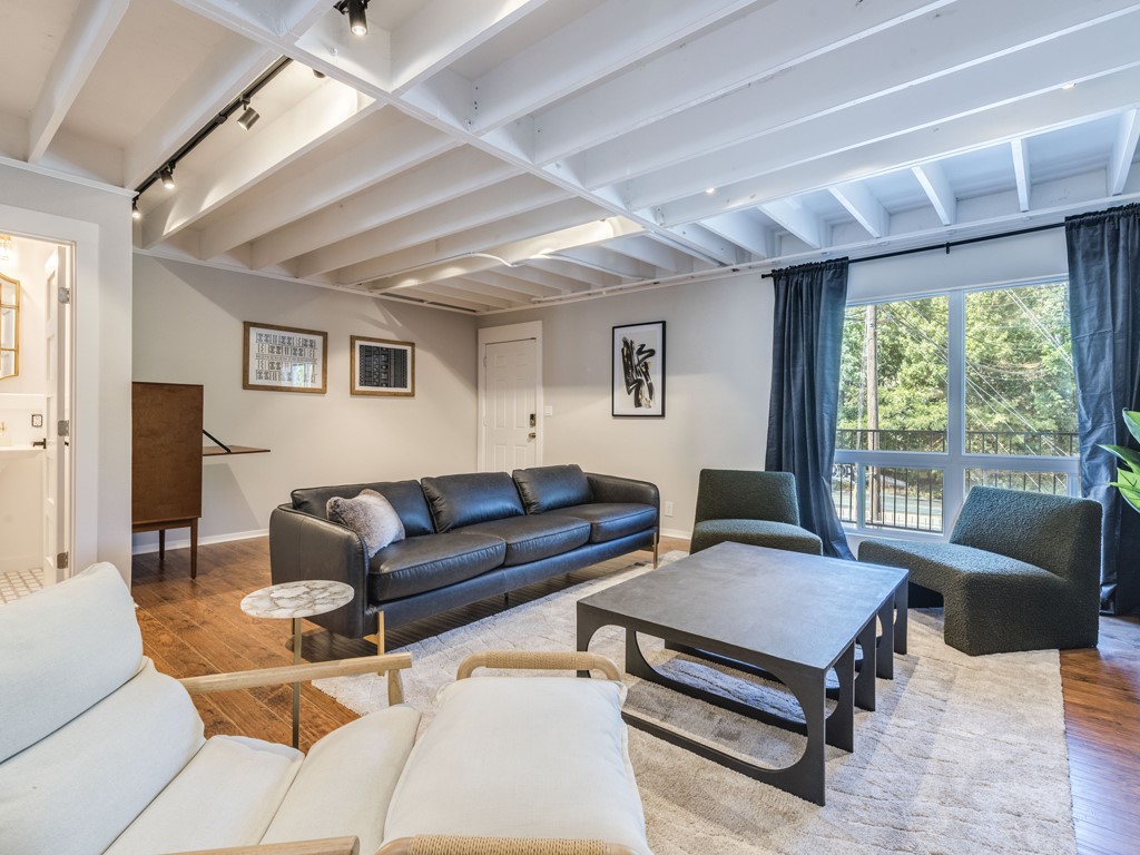 500 East Riverside Drive, Unit 206 Austin, TX 78704 - Photo 5 of 32 Living room with hardwood / wood-style floors, track lighting, and beam ceiling