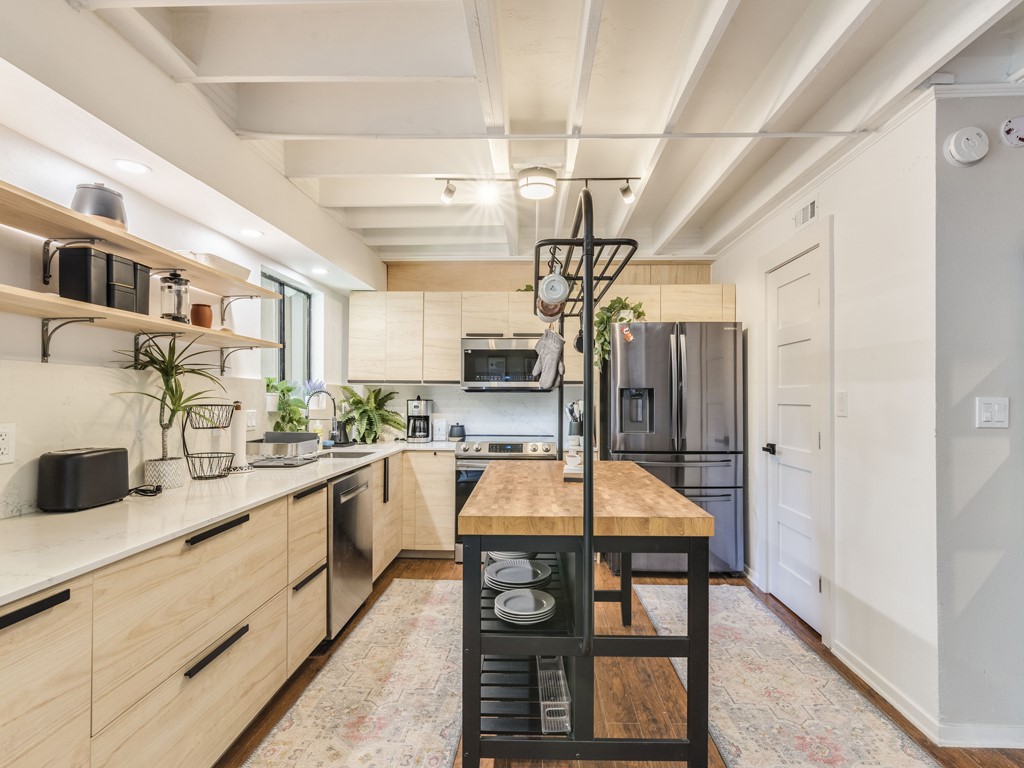 500 East Riverside Drive, Unit 206 Austin, TX 78704 - Photo 8 of 32 Kitchen featuring light wood finish cabinetry, open shelves, stainless steel appliances, and light stone counters