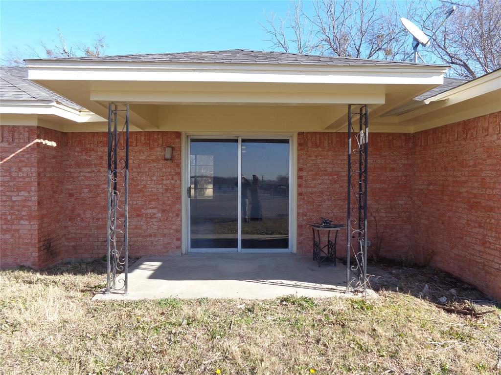612 South Files Street Itasca, TX 76055 - Photo 27 of 30 Property entrance with brick siding and a patio area