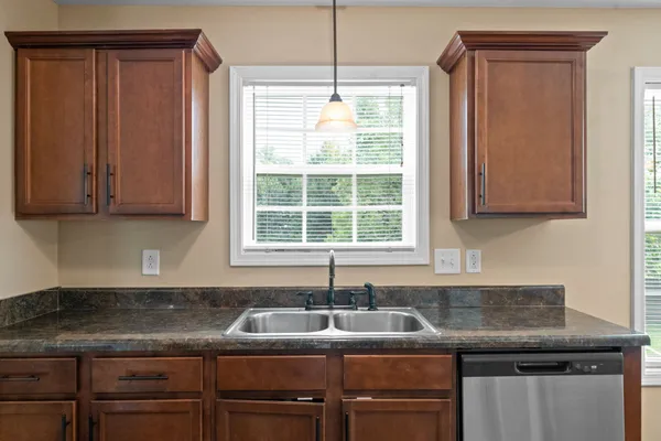 a kitchen with granite countertop cabinets sink and window