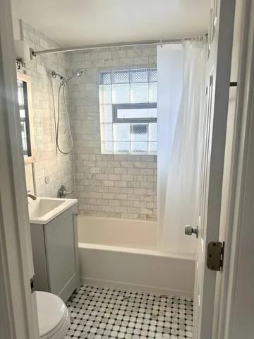 a bathroom with a bathtub shower and toilet