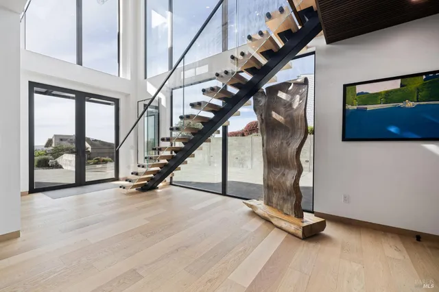 a kitchen with stainless steel appliances granite countertop a stove a refrigerator a oven a sink with a dining table and chairs with wooden floor