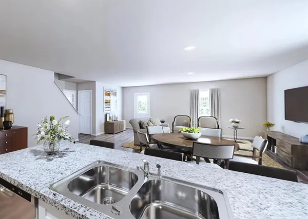 a living room with furniture and a kitchen area