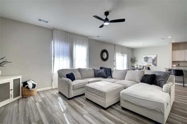 a living room with couches and a view of kitchen