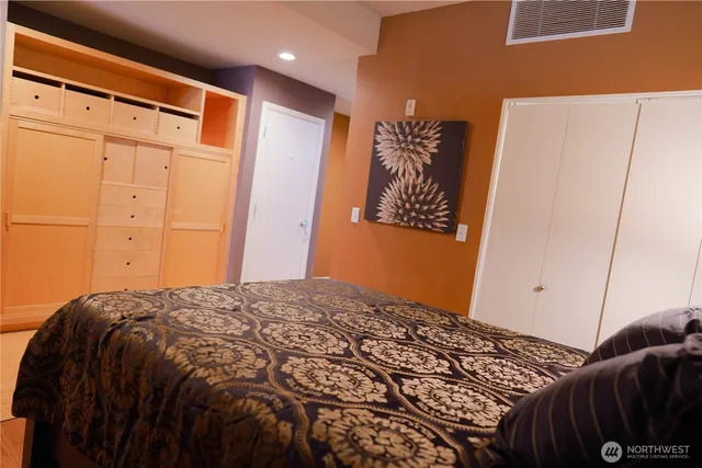 a bedroom with a bed and a painting on the wall