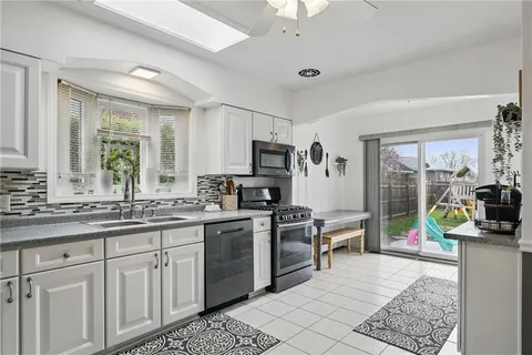a kitchen with stainless steel appliances granite countertop sink stove and refrigerator