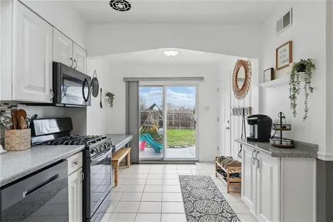 a kitchen with stainless steel appliances granite countertop a stove a sink and a microwave
