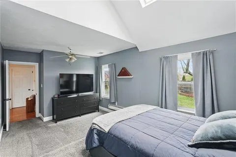 a bedroom with a bed and a flat tv screen on dresser