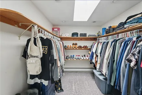 a view of walk in closet with clothes and shoes