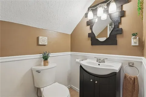 a bathroom with a sink mirror and toilet