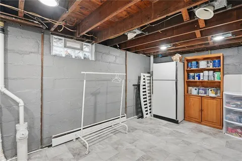 a view of water heater room with refrigerator