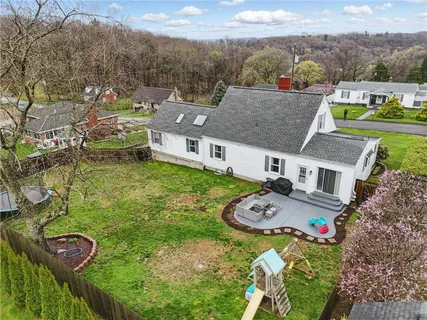 an aerial view of a house with garden space and ocean view