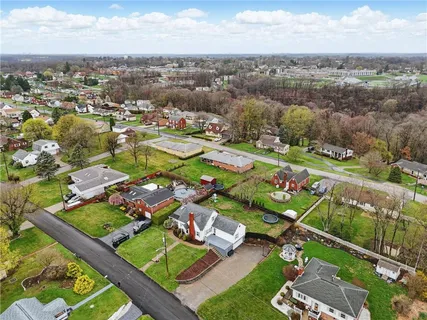 an aerial view of a residential houses with outdoor space and city view