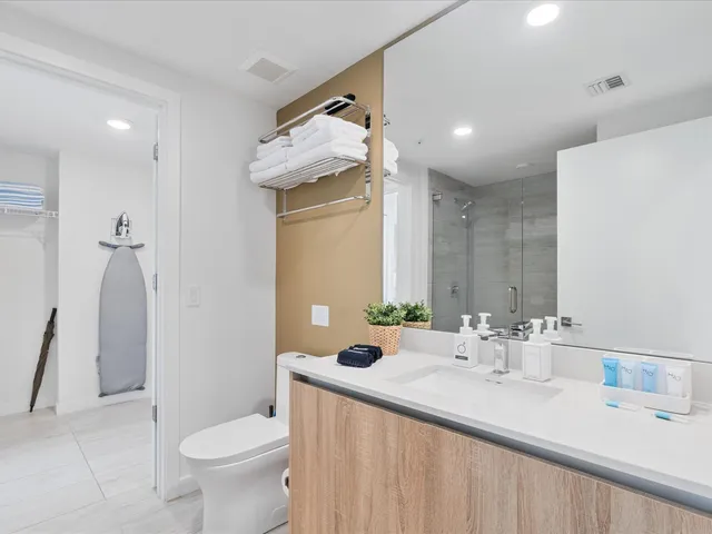 a bathroom with a double vanity sink toilet and shower